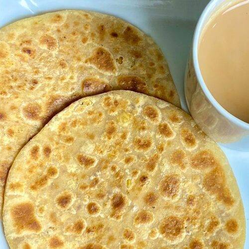 Two Chana Dal Sweet and Sour Parathas served with a cup of tea