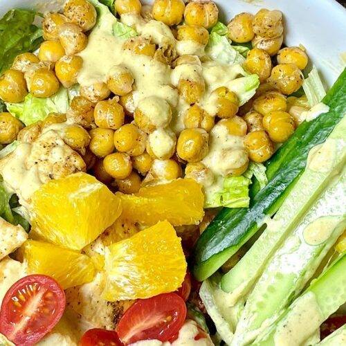 A bowl of Healthy Chickpea and Tofu Salad with fresh vegetables and herbs