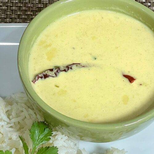 A bowl of Kokum Coconut Kadhi garnished with fresh coriander leaves