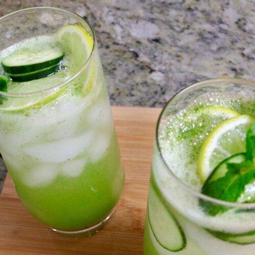 Refreshing Mojito Mocktail served in tall glasses with cucumber slices, lemon, and mint leaves.