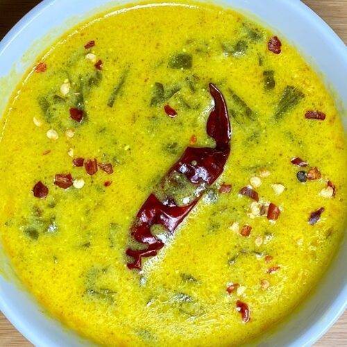 A bowl of creamy Palak Kadhi garnished with fresh spinach leaves