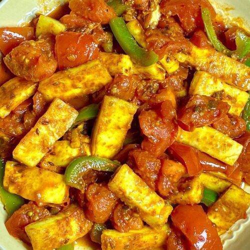 A bowl of vibrant Paneer Tomato Curry with bell peppers and fresh tomatoes