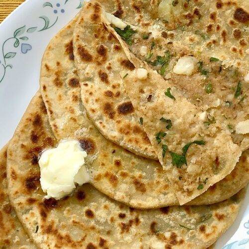 A plate of Aloo Paratha topped with a dollop of butter