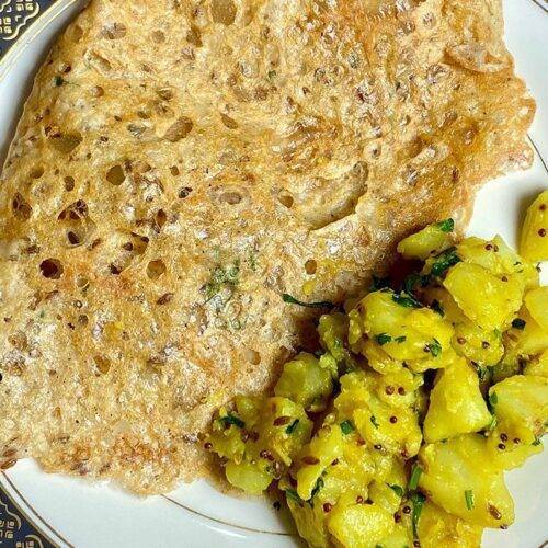 A plate of crispy Sorghum Dosa served with spiced potato filling